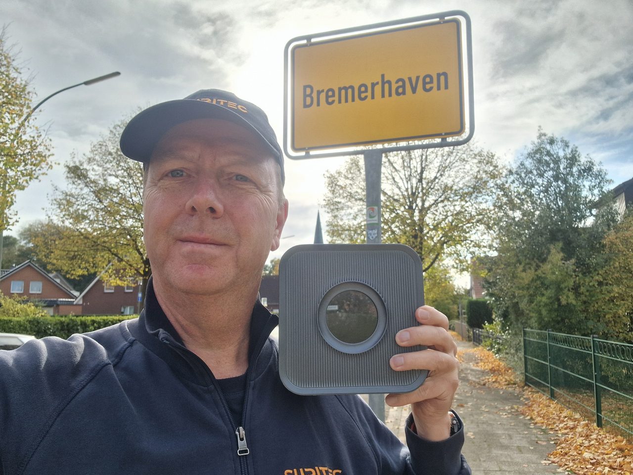 Michael Meyer mit dem Frühwarnsystem FRED am Ortsschild Bremerhaven
