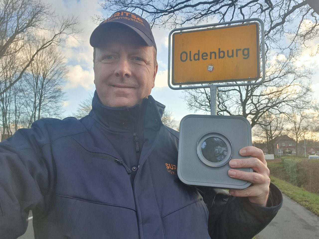Michael Meyer mit dem Frühwarnsystem FRED am Ortsschild Oldenburg
