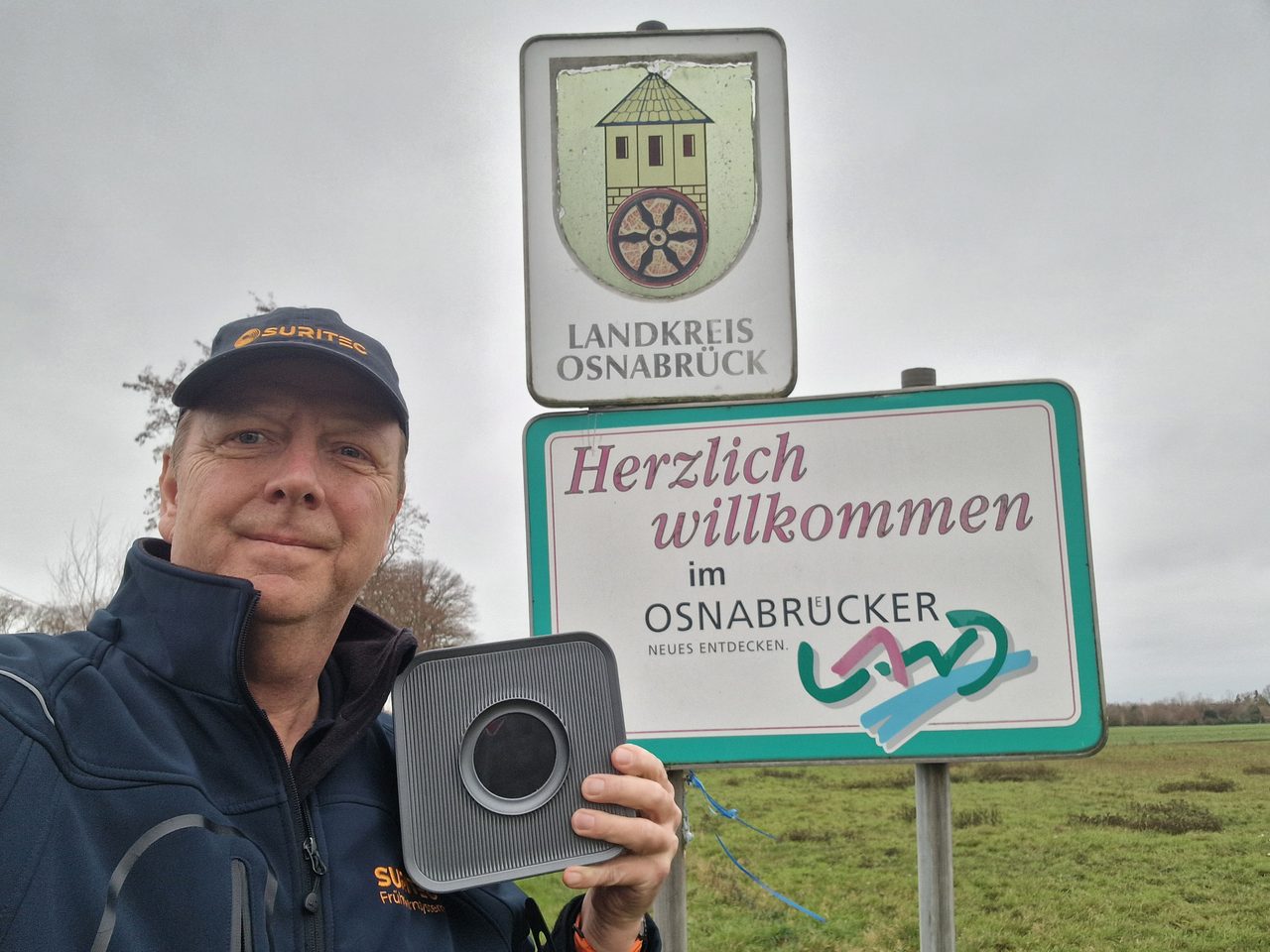Michael Meyer mit dem Frühwarnsystem FRED am Willkommensschild des Landkreises Osnabrück
